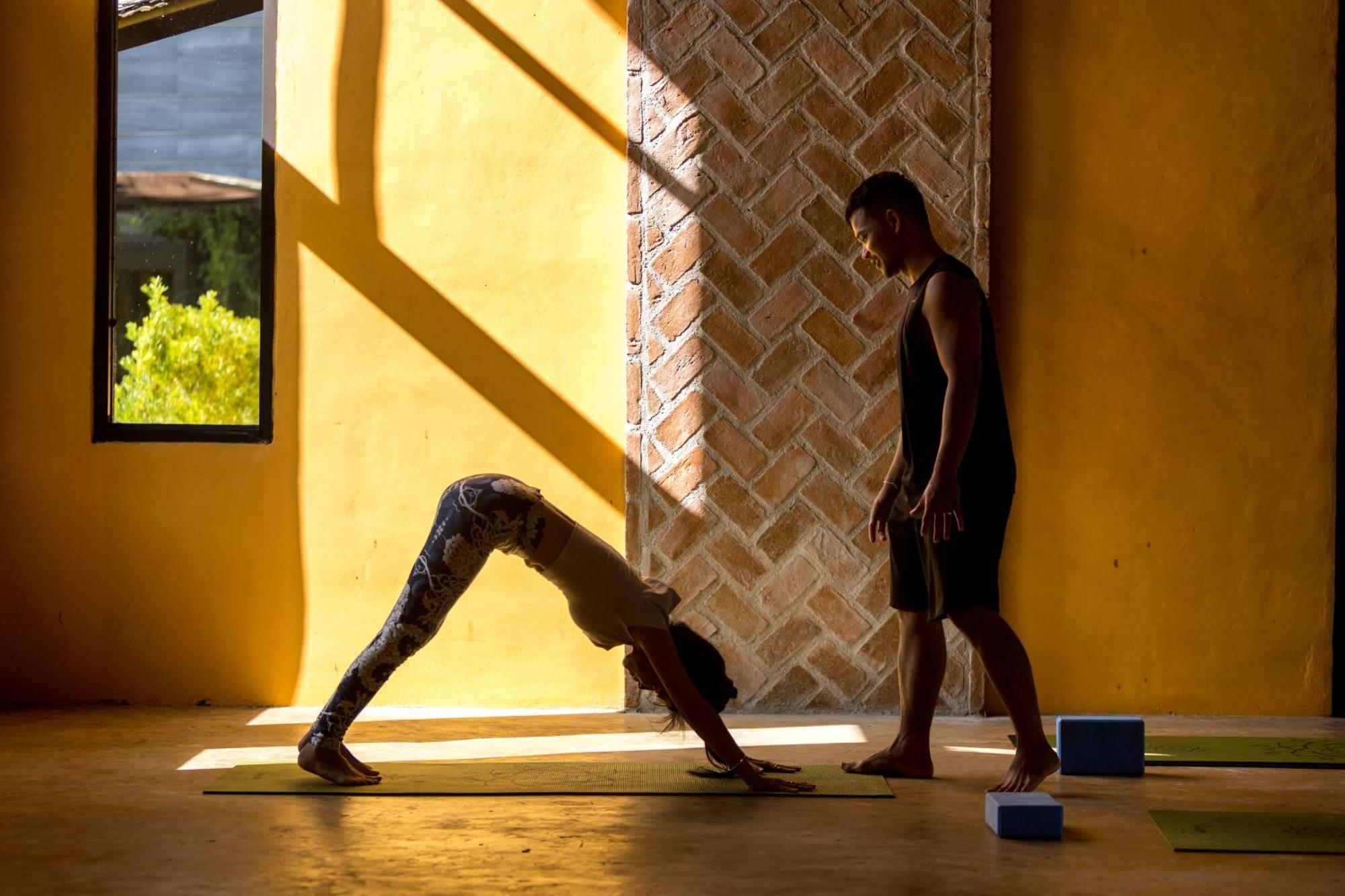 Anana Ecological Resort Krabi - Sha Extra Plus Ao Nang Bagian luar foto A yoga instructor assists a student with downward-facing dog.